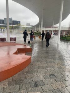 Personer går langs gangvei ved bygninger