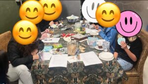 Nærbilde av bord med papir, kopper, lim og tegnesaker