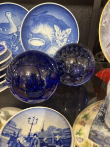 Blå glasskuler og dekorative glassgjenstander i bruktbutikken