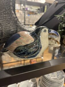 Keramikkfigur av fugl blant butikkens unike gjenbruksfunn