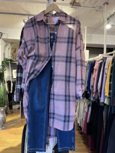 Skjorte og klær presentert på kleshenger i bruktbutikken