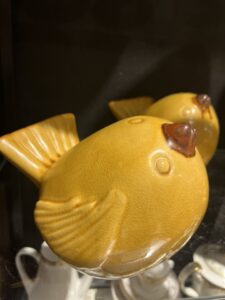 Gul keramikkfigur i form av en fugl utstilt i butikken