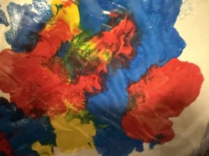 Nærbilde av maling i røde, blå og gule farger på underlag