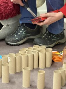 Ulike pappbiter og gjenbruksmaterialer ligger klare på gulvet