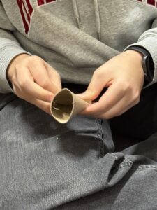 Nærbilde av hender som bretter og klipper papp