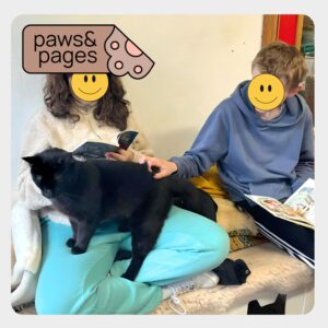 Children holding a book during a Paws & Pages session