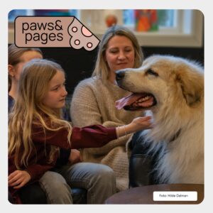 Children sitting together with a dog during a reading activity