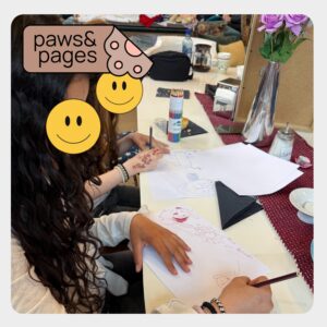 Child drawing while seated on the floor during Paws & Pages